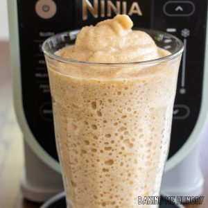coffee slushy recipe in a glass in front of the ninja slushi machine close up