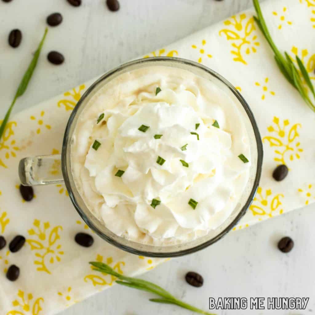 lavender latte recipe in wide glass mug from overhead sprinkled with lavender blossoms