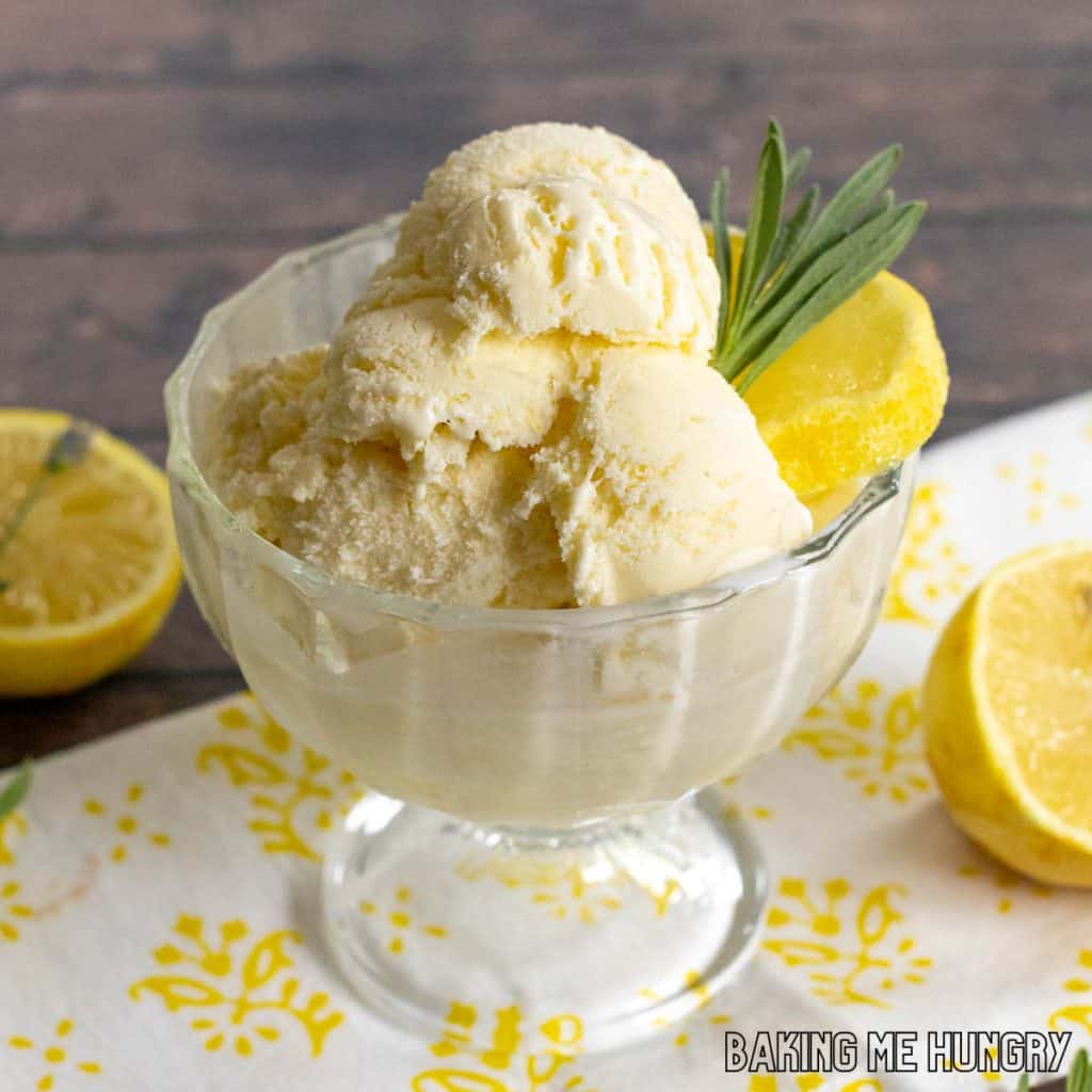 lavender lemonade ice cream in a glass bowl garnished with lemon slices and fresh lavender