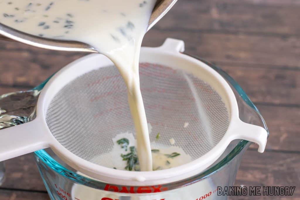 lavender milk being poured through strainer