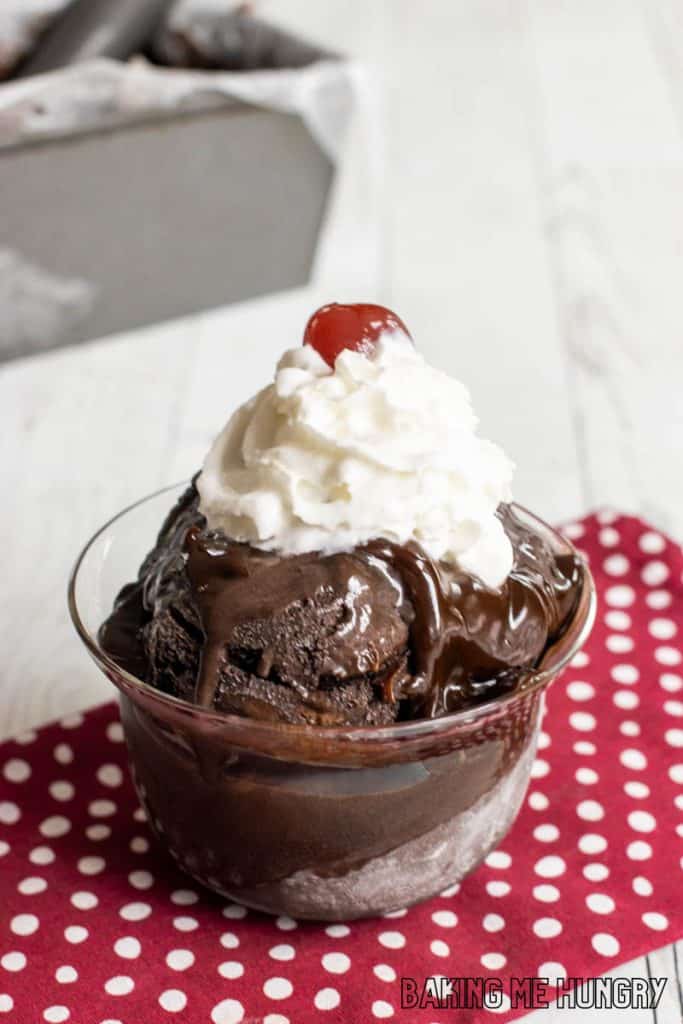 brownie batter ice cream recipe in dish with whipped cream and a cherry