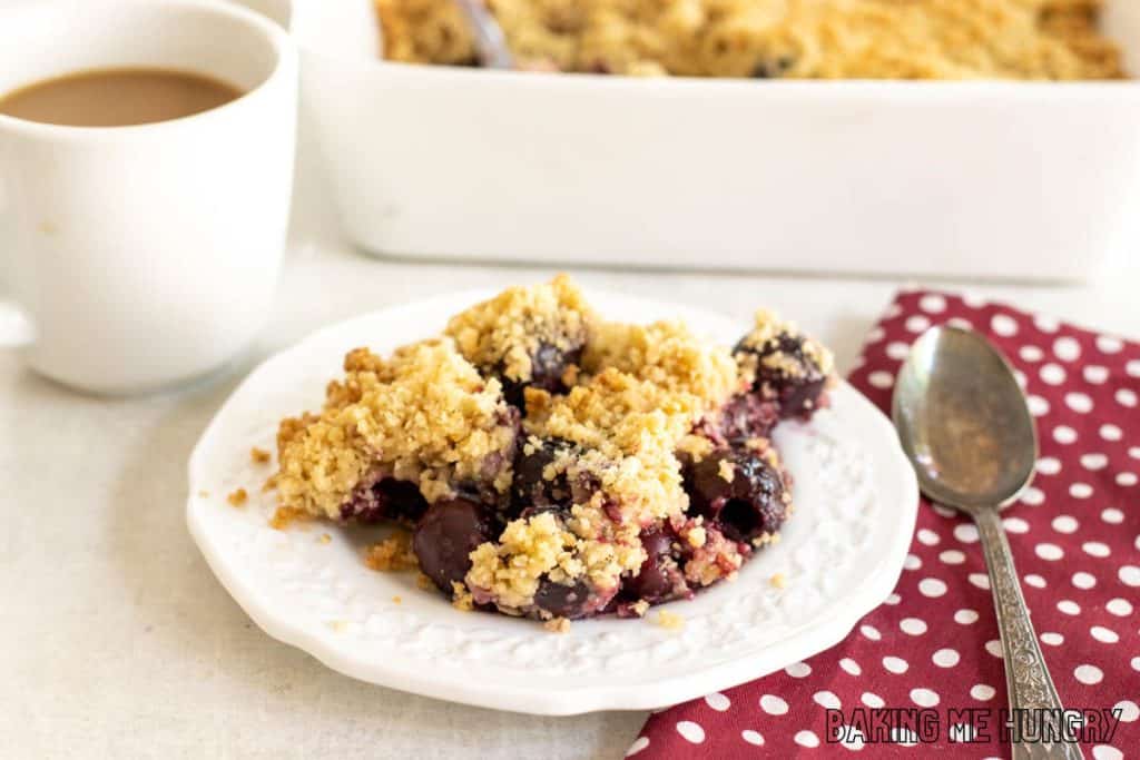 fresh cherry crumble recipe on plate with baking dish behind