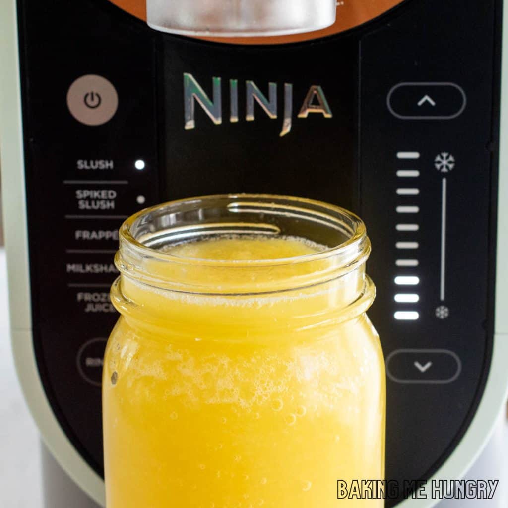 ninja slushi machine with slushie in jar in front of it
