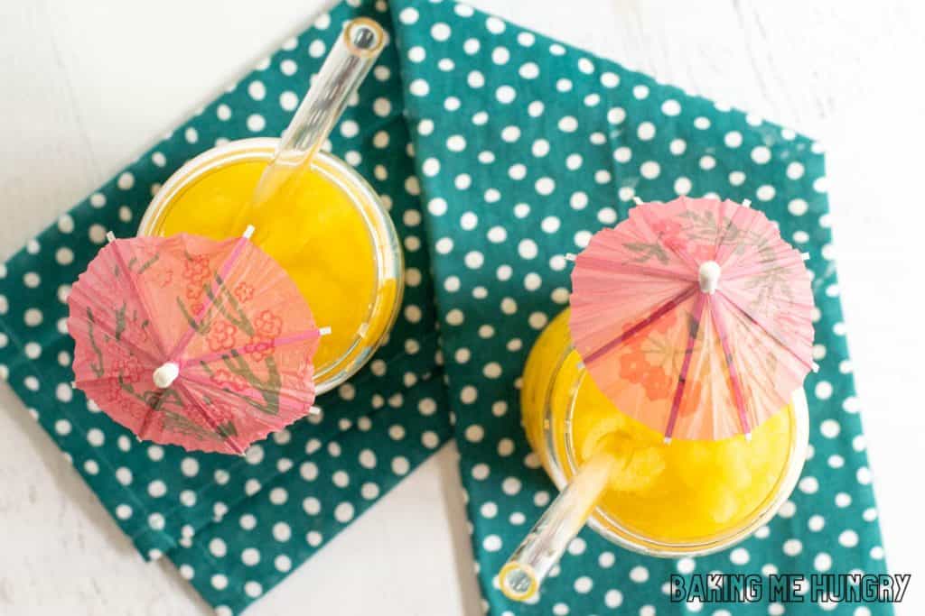 mango slushy recipe overhead shot of mango slushy in two glasses with paper straws