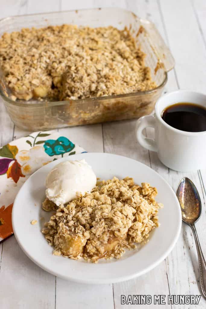 banana crisp served with vanilla ice cream with baking dish behind