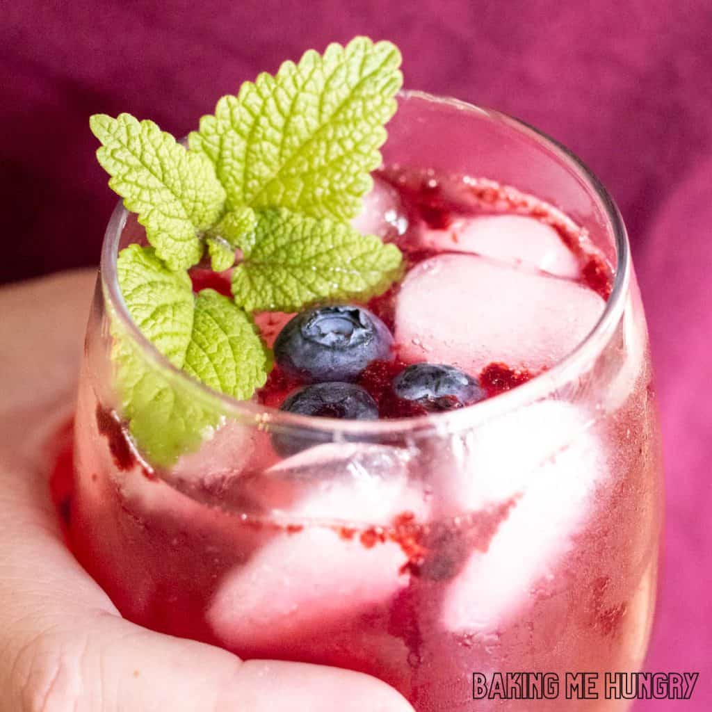 hand holding a blueberry mocktail