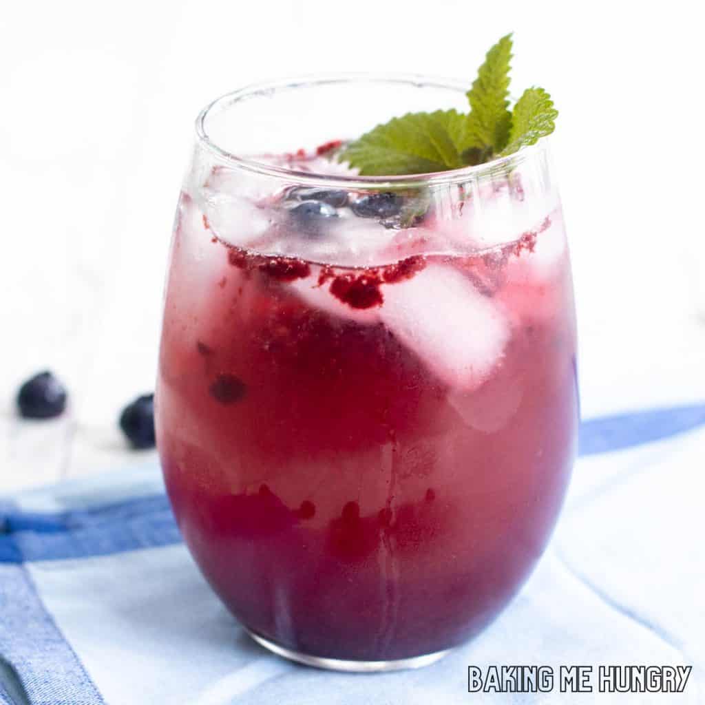 blueberry mocktail in stemless wine glass with mint and blueberries as garnish