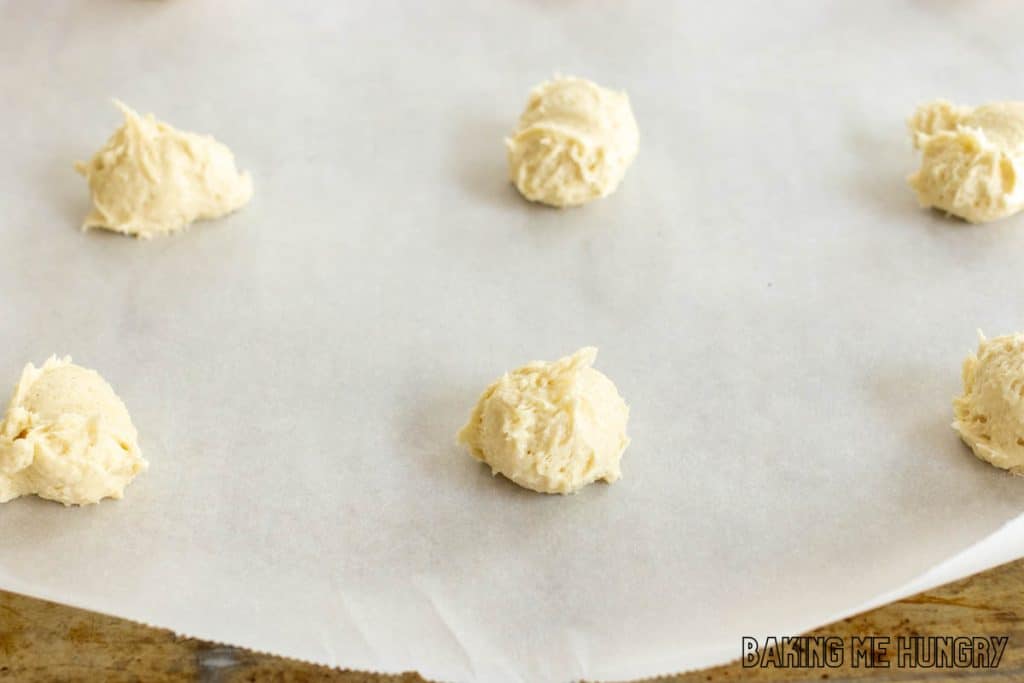 balls of cookie dough on baking sheet with parchment