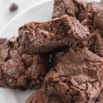double chocolate brownies on a plate with top brownie missing a bite