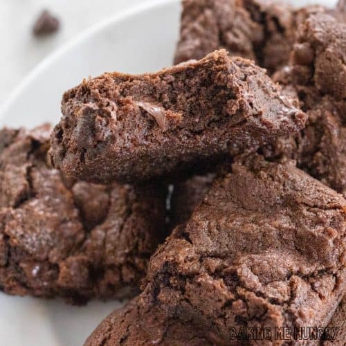 double chocolate brownies on a plate with top brownie missing a bite