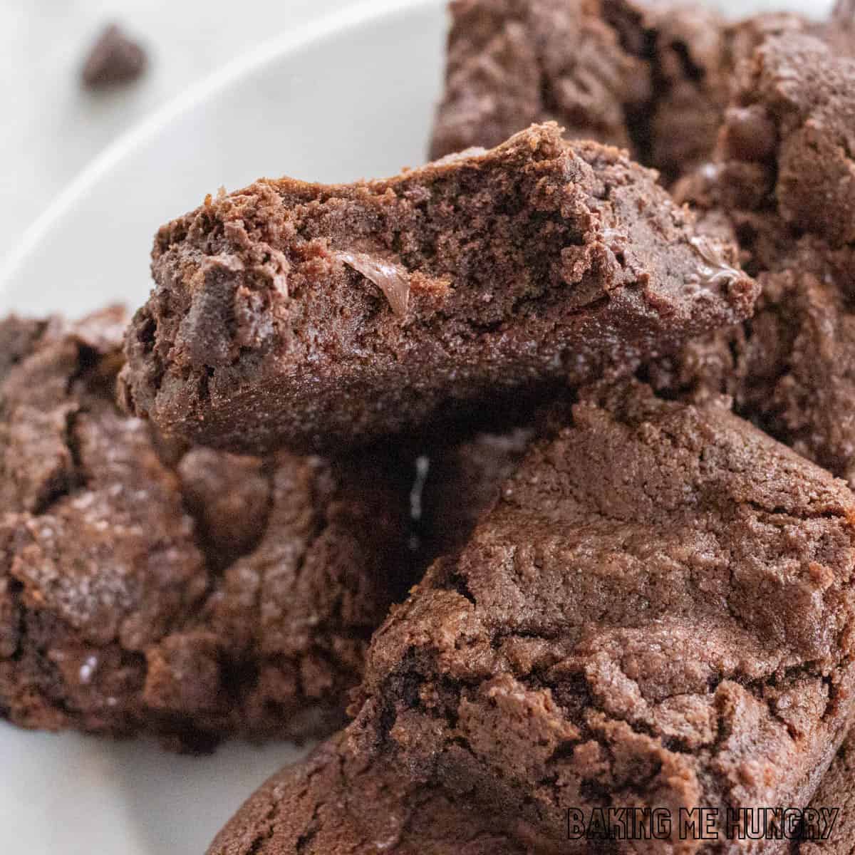 double chocolate brownies on a plate with top brownie missing a bite