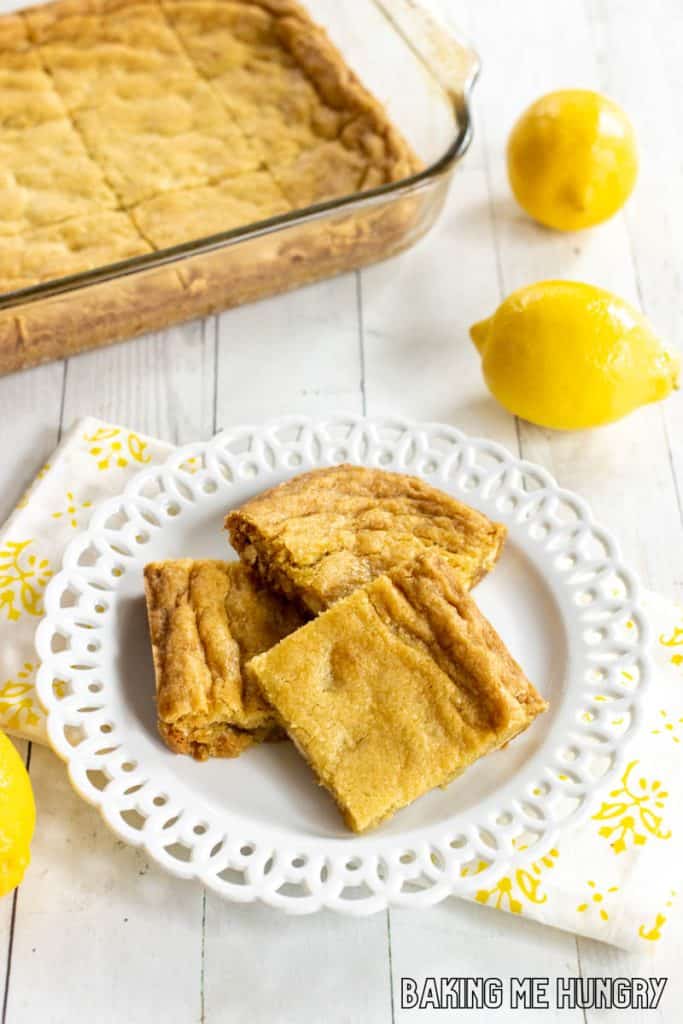 lemon blondies on a decorative plate with pan behind