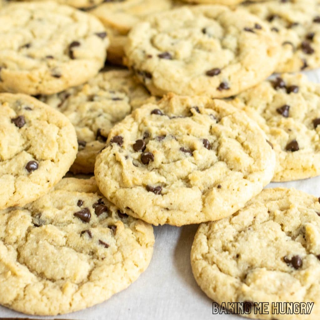 chocolate chip sugar cookies piled on baking sheet