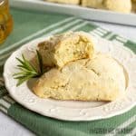 herb scones on a small plate close up with top scone missing a bite