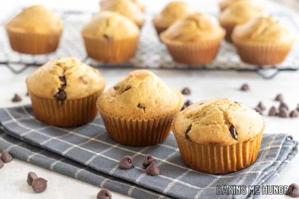 three of the peanut butter chocolate chip muffins on a blue napkin