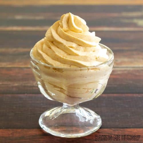 pumpkin mousse piped into a pedestal dish in wood backdrop