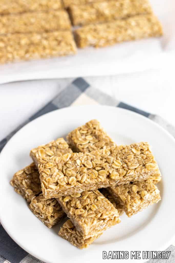 plate of honey oat bars with cutting board and remaining bars behind