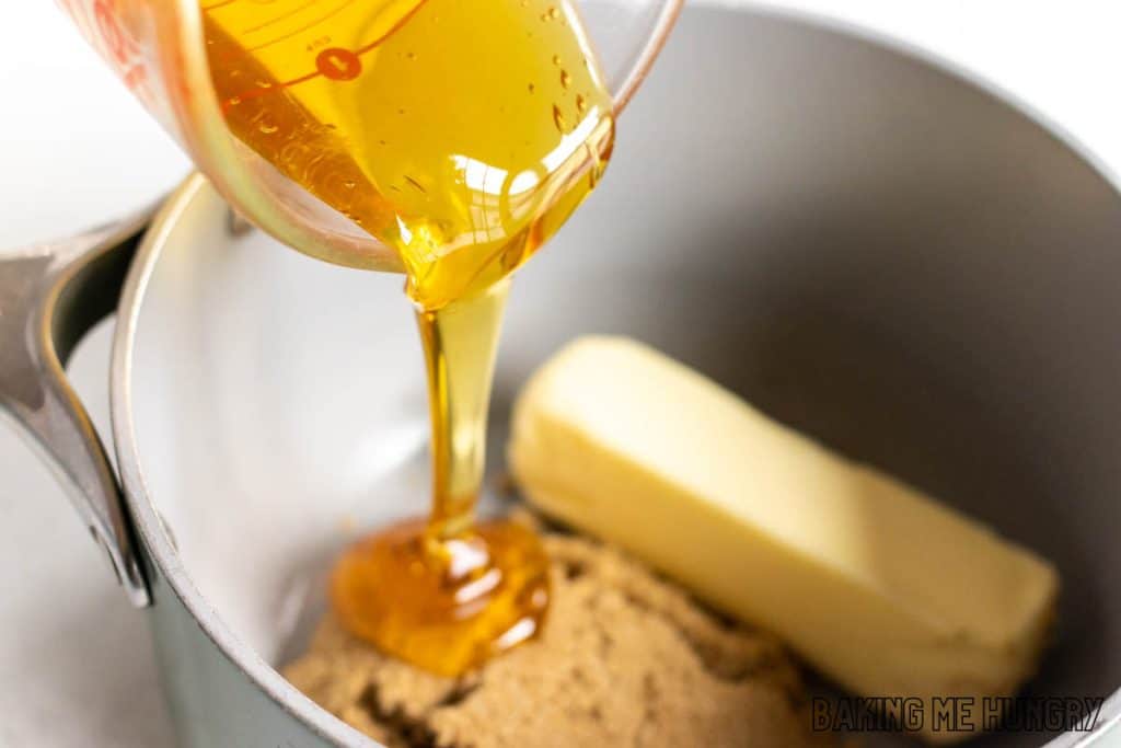 honey being poured into saucepan with butter and sugar