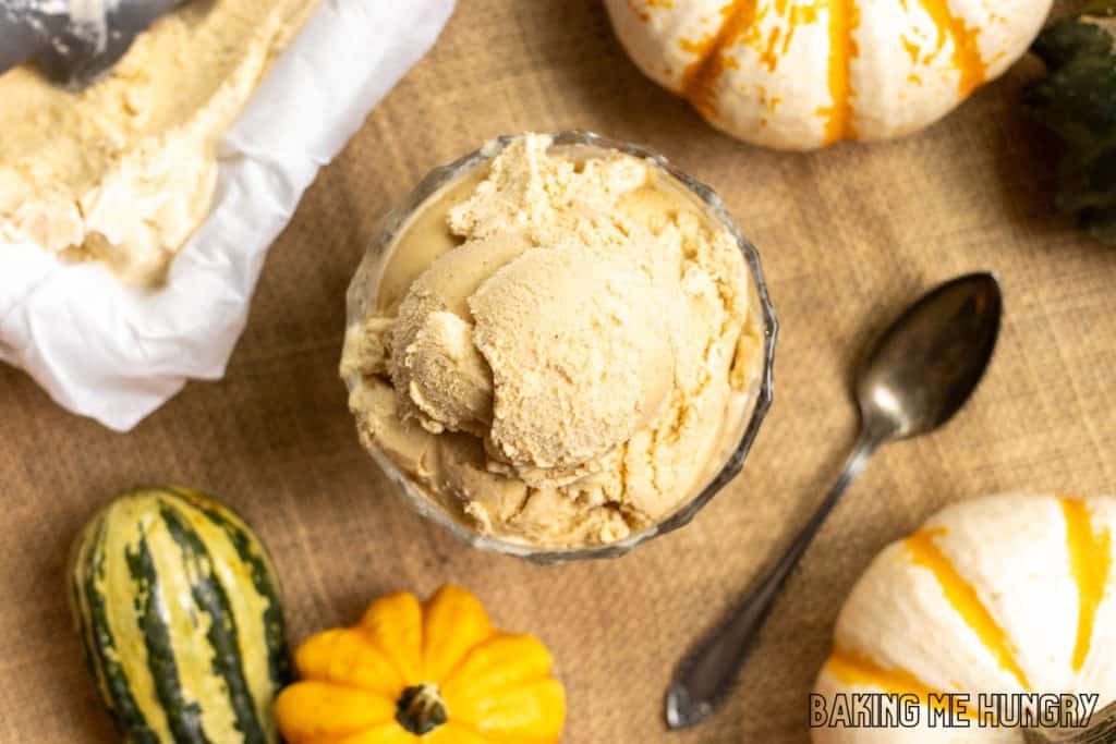 pumpkin spice ice cream served in pedestal bowl from overhead with pumpkins in background