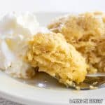 maple mug cake close up with a bite on a fork and whipped cream from the side