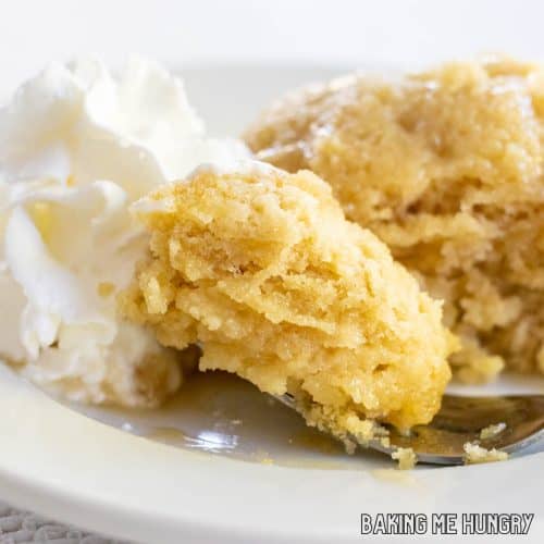 maple mug cake close up with a bite on a fork and whipped cream from the side