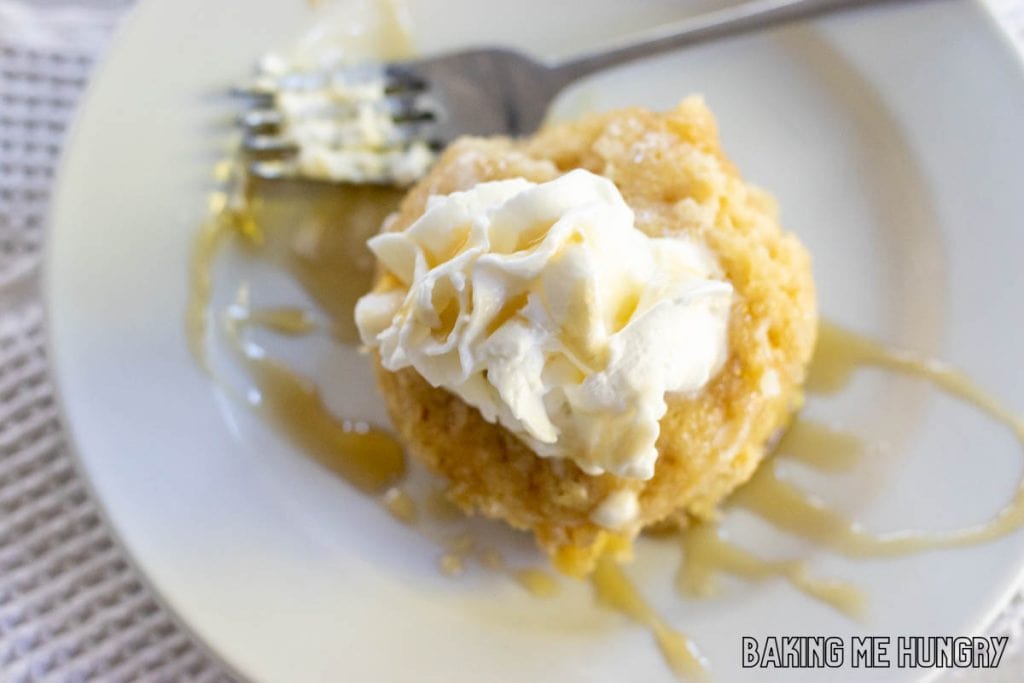 maple mug cake topped with whipped cream and maple syrup from overhead