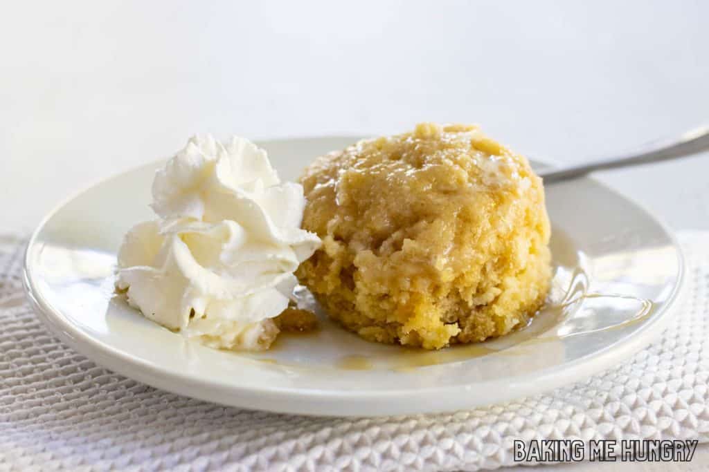 maple mug cake inverted onto small plate with whipped cream